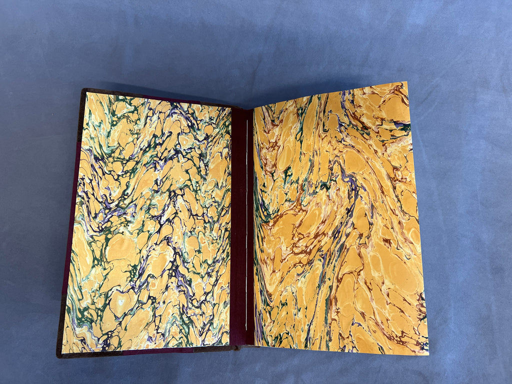 Open book with marbled yellow, red, purple  pages on a gray background
